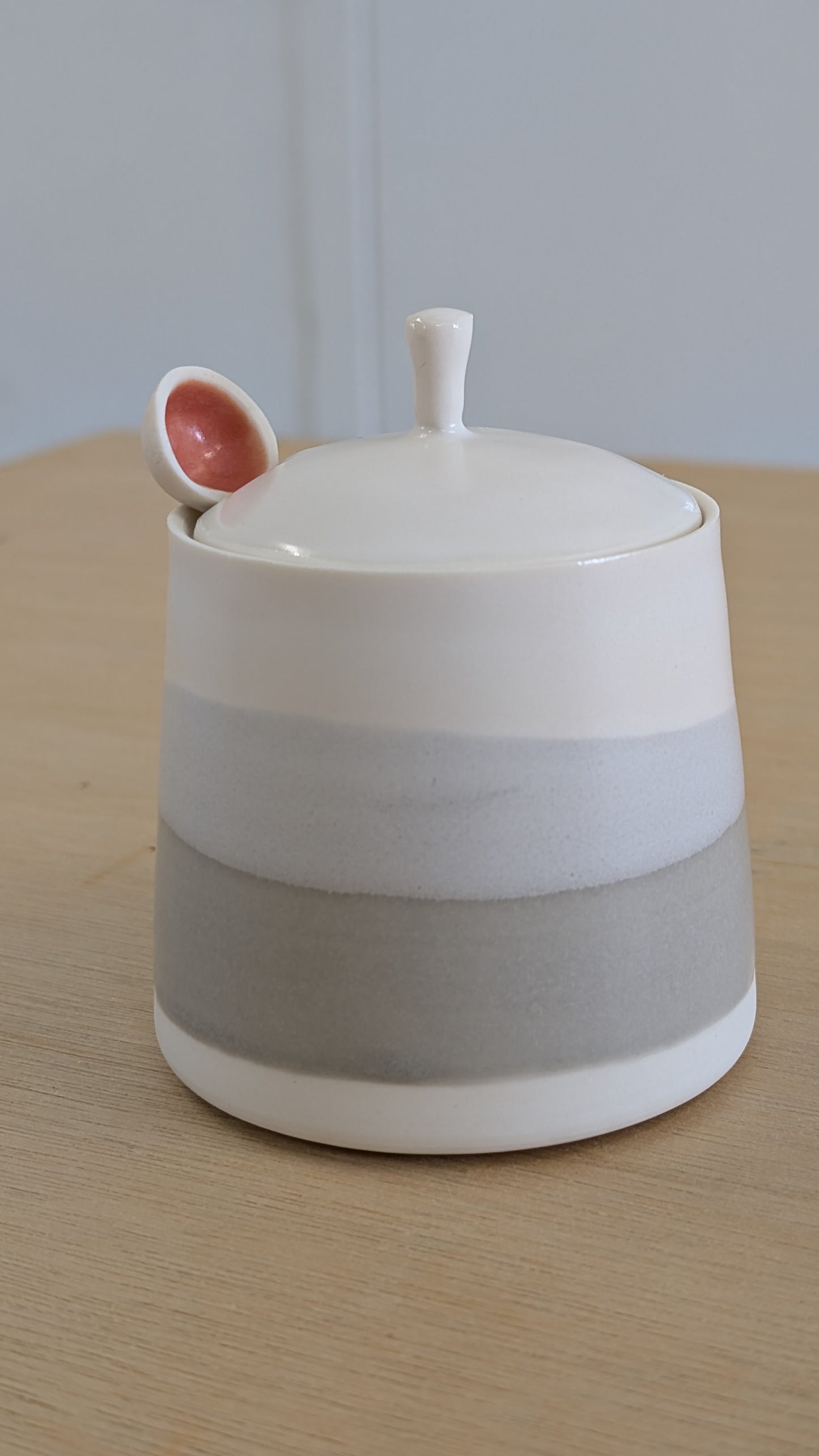 Grey and white wash lidded pot with porcelain spoon.